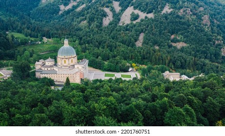 Aerial View Of The Sanctuary Of Oropa, Roman Catholic Building In The Biellese Alps, Northern Italy. Tourist Attraction And Famous Place Of Pilgrimage In Piedmont. Drone Photography.