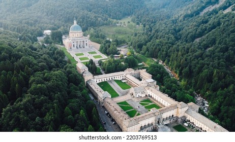 Aerial View Of The Sanctuary Of Oropa, Roman Catholic Building In The Biellese Alps, Northern Italy. Tourist Attraction And Famous Place Of Pilgrimage In Piedmont. Drone Photography.