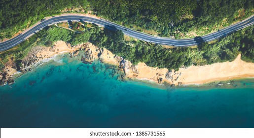 Aerial View Of The Sandy Beach And Curved Asphalt Road 