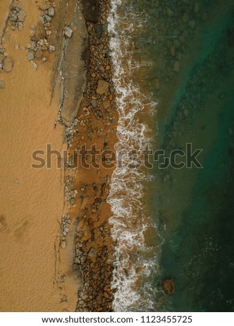 Similar – Luftpanorama-Drohne Blick auf die Meereswellen, die am felsigen Strand erdrücken.