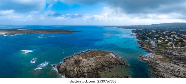 Aerial view of Sardinia's coastline with a rocky outcrop featuring an ancient tower. Rugged cliffs, turquoise waters, and a town in the background. - Powered by Shutterstock