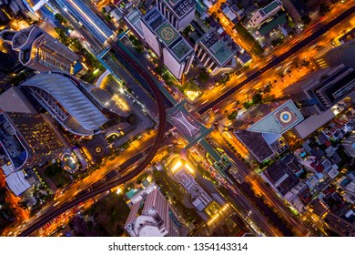 Aerial View Of Sathorn Intersection Or Junction With Cars Traffic, Bangkok Downtown, Thailand. Financial District And Business Area. Smart Urban City Technology. Skyscraper And Buildings At Night.