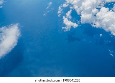 Aerial view scene of the sea or ocean which hiding under white fluffy clouds.
