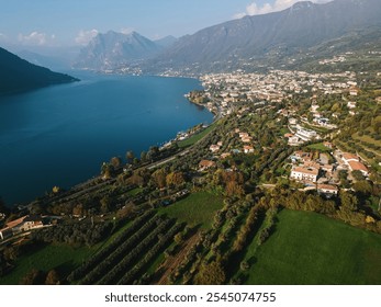 Aerial view of a scenic lakeside town surrounded by lush green hills and mountains - Powered by Shutterstock