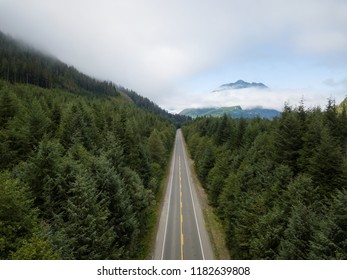 Aerial View Of A Scenic Road In The Canadian Landscape During A Vibrant Cloudy Summer Day. Taken In Northern Vancouver Island, BC, Canada.