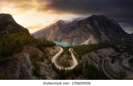 Aerial View Of A Scenic Road In The Canadian Mountain Landscape During A Cloudy Sunset. Sky Replacement Composite. Taken In Lillooet, BC, Canada.