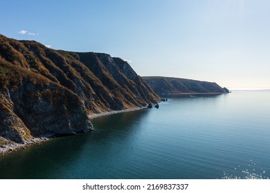 Aerial View Of The Sea Coast. Top View Of The Sea, Rocky Coast And Mountains. Sunny Weather. Autumn Season. Taui Bay, Sea Of Okhotsk. Nature Of The Magadan Region And Siberia. Far East Of Russia.