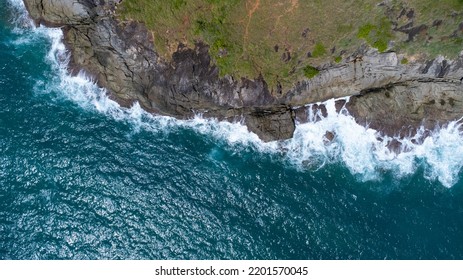 Aerial view of sea waves crashing on rocks cliff in the blue ocean. Top view of coastal rocks in Phuket ocean. Landscape view point of Laem Phromthep Cape in the morning. - Powered by Shutterstock