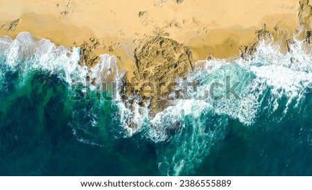 Aerial view of sea waves and fantastic Rocky coast. Aerial view Top down seashore. Waves crashing on rock cliff. Aerial drone top view of ocean's beautiful waves crashing on the rocky island coast. 