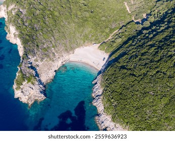 Aerial view of secluded beach nestled in a cove with turquoise water and lush greenery. - Powered by Shutterstock