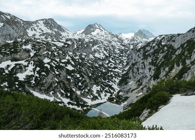 Aerial view of serene alpine lake Hölltalsee (Silberkarsee) surrounded by majestic snow-capped mountain peak in Ramsau am Dachstein, Styria, Austria. Hiking trail in Austrian Alps. Schladminger Tauern - Powered by Shutterstock