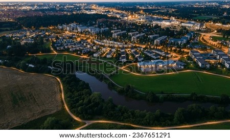 Aerial view of a serene residential neighborhood in the suburbs of Helsinki, Finland, featuring townhouses and a small river