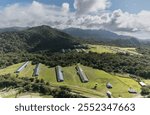 Aerial view of several poultry houses in a valley surrounded by beautiful mountains