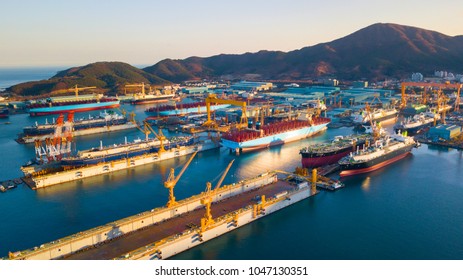 Aerial view of shipyard in the bay. Image consist of many commercial ship, platform, floating dock and large crane.