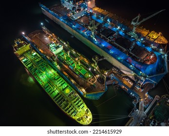 Aerial View Shipyard Dry Dock Maintenance And Repair Container Ship Transport And Oil Ships In Sea, Business And Industry Service At Night Over Lighting Photograph From Drone,