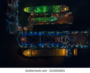 Aerial View Shipyard Dry Dock Maintenance And Repair Container Ship Transport And Oil Ships In Sea, Business And Industry Service At Night Over Lighting Photograph From Drone,