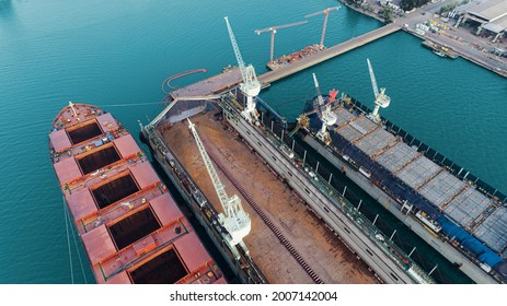 Aerial View Shipyard Have Crane Machine And Container Ship In Green Sea .