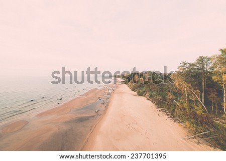 aerial view to the Shoreline of Baltic sea beach with rocks and sand dunes under clouds - retro, vintage style look