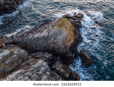 An aerial view showcasing a rugged rocky coastline with dramatic ocean waves breaking along the shore, capturing the tranquility and raw beauty of nature at sunset on Vancouver Island. - Powered by Shutterstock