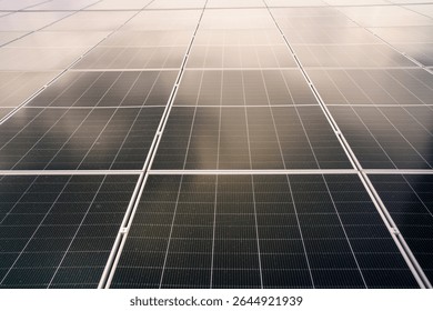 Aerial view showing a solar panels array on factory - warehouse rooftop close up. Solar cell array installed on the building rooftop, renewable and sustainable energy concept.