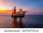 Aerial view of silhouette offshore jack up drilling rig during sunset - oil and gas industry