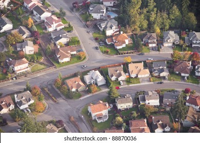 Aerial View Of Single Car Driving On A Neighborhood Road