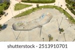 Aerial view of a skateboarding playground in a city park. There are no children and the playground is empty.