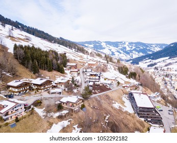 Aerial view of the ski resort winter town or village in the Alps with small houses, outdoor pool ski lifts and slopes