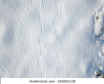 Aerial View Of Ski Tracks In Snow. Backcountry Skiing In Powder, Leaving Trails In Snow.