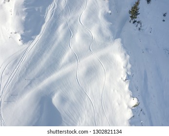 Aerial View Of Ski Tracks In Snow. Backcountry Skiing In Powder, Leaving Trails In Snow.