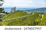 Aerial view of the Sky Bridge 721, the worlds longest suspension footbridge, stretching across a forested mountain in Czechia. The unique Sky Walk lookout tower stands nearby, offering panoramic views