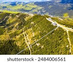 Aerial view of the Sky Bridge 721, the worlds longest suspension footbridge, stretching across a forested mountain in Czechia. The unique Sky Walk lookout tower stands nearby, offering panoramic views