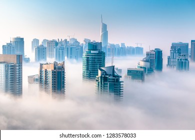 Aerial View Of Skyscrapers In The Clouds. Morning Winter Fog Over Dubai Marina. City Above The Clouds 