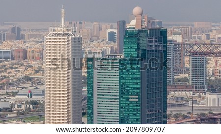 Aerial view of skyscrapers with World Trade center in Dubai timelapse. Bur Dubai and Deira district on a background