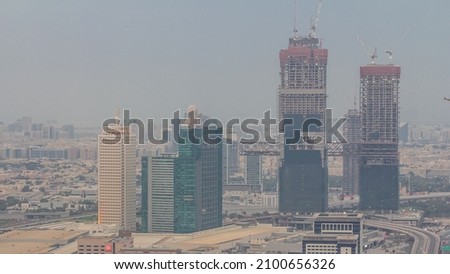 Aerial view of skyscrapers with World Trade center in Dubai day to night transition timelapse after sunset. Construction site of new twin towers. Bur Dubai and Deira district on a background