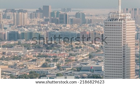 Aerial view of skyscrapers with World Trade center in Dubai timelapse at evening. Bur Dubai and Deira district on a background with houses and shops