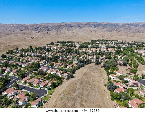 南カリフォルニア州ベンチュラ郡ムーアパークの背景に小さな地域と乾燥した砂漠の山の空撮 米国 の写真素材 今すぐ編集