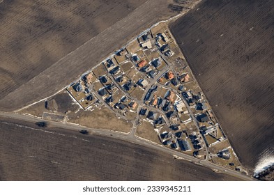 Aerial view of a small settlement with fields, triangle. Agricultural landscape with houses.