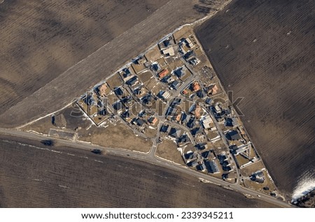 Aerial view of a small settlement with fields, triangle. Agricultural landscape with houses.