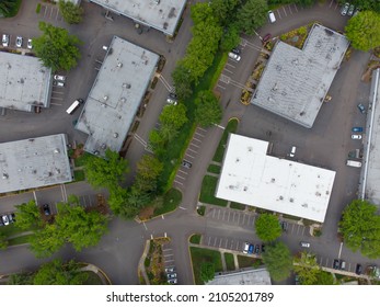 Aerial View. Small Suburb. Industrial Zone. Roofs Of Large One-story Rooms. Garages. Warehouses. Lots Of Greenery. Paved Roads. Cars. There Are No People In The Photo.