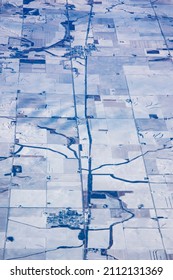 Aerial view of small towns surrounded by frozen cropland in an Iowa winter.