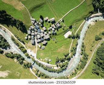 Aerial view of small village in alpine valley in Switzerland. Small houses beside river in Goms. Building roofs from above. - Powered by Shutterstock