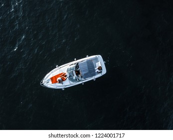 Aerial view of the small yachts floating in the sea by the coast with people on it.