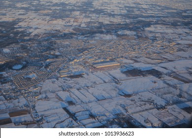 An Aerial View Of Snow Covered Buildings, Farm Fields, And A Rural Landscape In The Early Morning Light In Thunder Bay, Ontario, Canada.