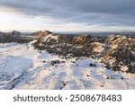 Aerial view of snow covered mountains at sunset in Obarenes mountain range, Burgos province, Spain.