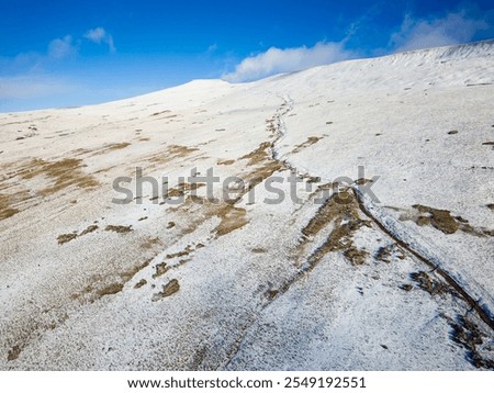 Aerial view of the snow covered path from Pont-ar-Daf to the summit of Corn Du and Pen-y-Fan in the Brecon Beacons