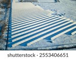 Aerial view of snow covered sustainable electric power plant with rows of solar photovoltaic panels for producing clean electrical energy. Low effectivity of renewable electricity in northern winter