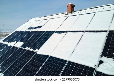 Aerial View Of Snow Melting From Covered Solar Photovoltaic Panels Installed On House Rooftop For Producing Clean Electrical Energy. Low Effectivity Of Renewable Electricity In Nothern Region Winter