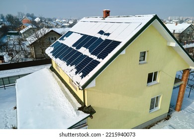 Aerial View Of Snow Melting From Covered Solar Photovoltaic Panels Installed On House Rooftop For Producing Clean Electrical Energy. Low Effectivity Of Renewable Electricity In Nothern Region Winter