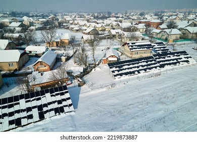 Aerial View Of Snow Melting From Covered Solar Photovoltaic Panels Installed On House Rooftop For Producing Clean Electrical Energy. Low Effectivity Of Renewable Electricity In Nothern Region Winter